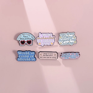 Set of 6 motivational enamel pins with colorful song lyric quotes on pink background