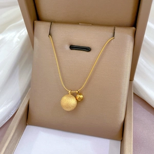 Minimalist gold titanium steel double ball pendant necklace on silk in a jewelry box