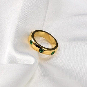 Bague en titane plaqué or 18K avec zircon vert sur fond de soie blanche élégante