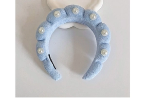 Close-up of a light blue padded sponge headband with elegant white pearl decorations