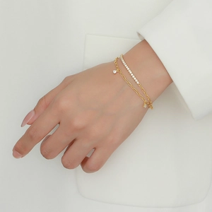 Close-up of elegant double-layered gold bracelet with pavé cubic zirconia and star charms