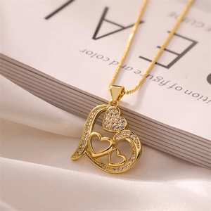 Detail der goldenen Herz-Halskette mit Zirkonia-Mikropavé auf weißer Seide und Buch