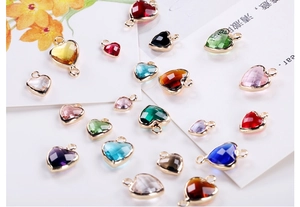 Macro view of multi-color faceted crystal heart pendants with gold-plated metal borders