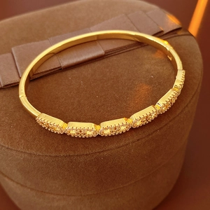 Macro view of gold clasp bracelet with rectangular cubic zirconia inlay on jewelry box