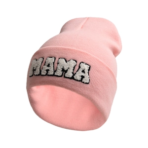 Detail of light pink knitted beanie featuring white fuzzy MAMA letter embroidery
