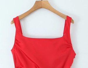 Detail of red sleeveless mermaid evening dress showing square neckline and glossy fabric