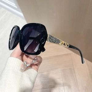 Chic oversized polarized sunglasses with black multifaceted frame and crystal-encrusted gold temples