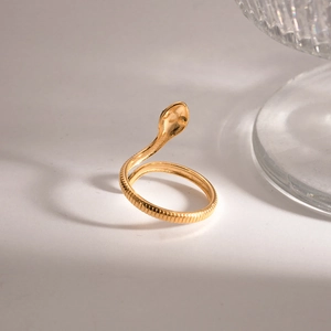 Close-up of a gold-plated snake-shaped open ring with a high-polished metallic finish