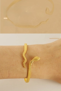 Macro detail of 18k gold plated snake bracelet showing scales and engraved snake texture