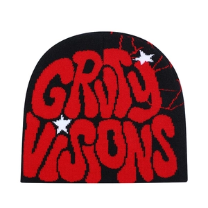 Detail of black knit beanie featuring red spider web pattern and white stars embroidery
