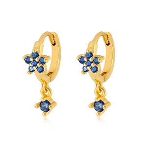 Close-up of gold star earrings with micro-set blue zircon stones and dangling round gems
