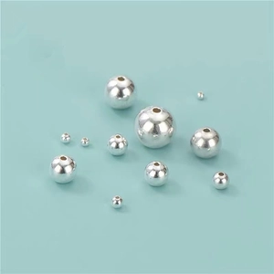 Detailed view of eleven polished S999 sterling silver loose beads with center holes