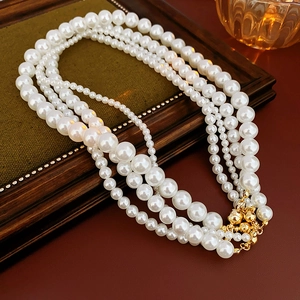 Detail of multilayer vintage pearl necklace with golden magnetic clasp in ornate frame