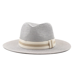 Detail of the light gray straw fedora hat featuring a beige and tan striped decorative band