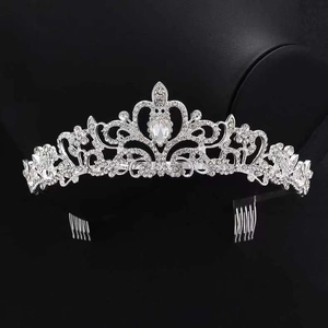 Close-up of silver rhinestone crown with sparkling teardrop crystals and hair combs
