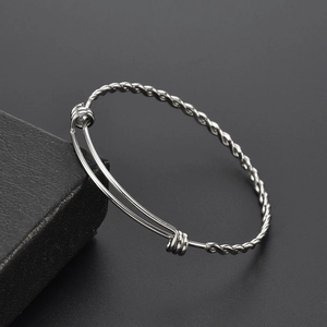 Adjustable silver twist bangle in stainless steel displayed on a minimalist gift box