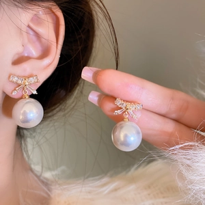 Elegant gold bow earrings with clear cubic zirconia and large round white pearls