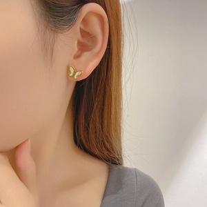 Elegant butterfly stud earrings in 18K gold plating worn by a model for a chic look