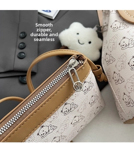 Détail de la fermeture éclair métallique et garniture en cuir brun sur sac à motif d'ours