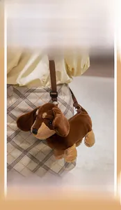 Detailed close-up of a plush dachshund crossbody bag featuring an adjustable strap