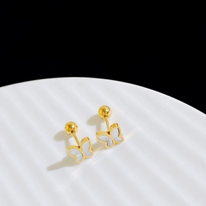 Close-up of golden butterfly studs with white mother of pearl inlay on wavy plate