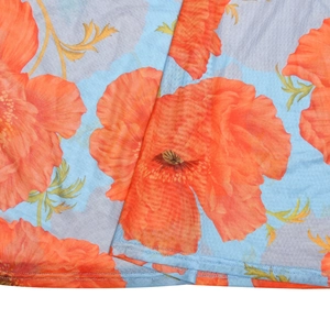Detailed macro view of orange poppy floral print on light blue mesh fabric material