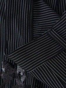 Détail du tissu de costume rayé noir avec broderie de paillettes et texture
