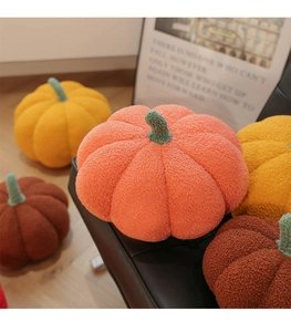 Close-up of plush pumpkin pillows in soft sherpa fabric with various autumn colors