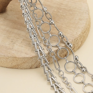 Multi-layer silver stainless steel chain necklace with geometric link designs on wood