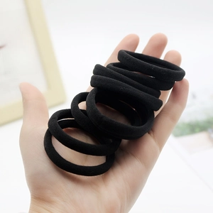 Set of 10 high-elastic black seamless hair ties for ponytails held in hand