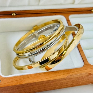 Polished gold and silver stainless steel bangles set in a luxury jewelry box