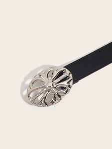 Detail of silver oval belt buckle with cutout design and sparkling rhinestones on black leather