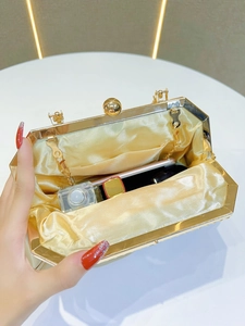 Internal view showing gold evening clutch capacity with lipstick and perfume inside