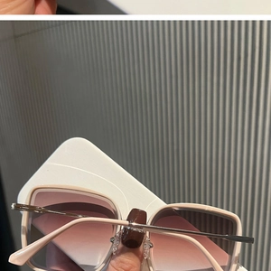 Détail de lunettes de soleil carrées beiges avec verres dégradés et branches fines