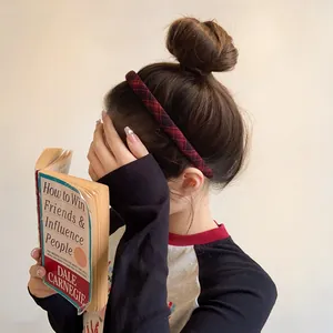 Detail view of a red and black plaid fabric headband worn by a model in vintage style