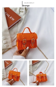 Detail view of mini orange jelly handbag with glossy finish and gold chain strap