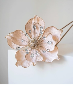 Detail of velvet magnolia flower with gold glitter edges and crystal stamens decoration