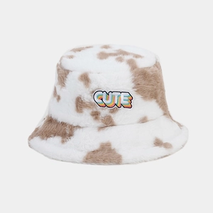 Vue détaillée du chapeau bob en peluche motif vache avec écusson brodé CUTE multicolore