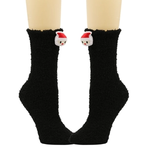 Detail von plüschigen schwarzen Korallenfleece-Socken mit einer 3D-Weihnachtsmann-Puppe
