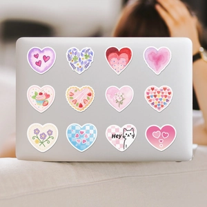 Close-up of decorative heart stickers in various patterns on a silver laptop surface