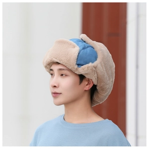 Close-up of winter trapper hat with thick brown faux fur lining and blue fabric top cover