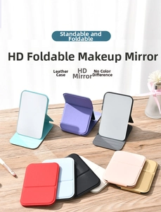 Close-up of portable folding makeup mirror with leather cover in various colors