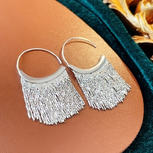 Gros plan détaillé des boucles d'oreilles argentées à franges avec chaînes métalliques