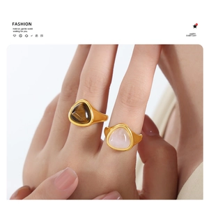 Close-up of matte gold rings with triangle tiger eye and pink quartz stones for couples