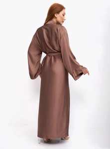 Vue détaillée du tissu satiné brillant et de la ceinture sur ce long peignoir marron