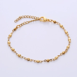 Detailed macro view of gold ball chain bracelet with lobster clasp and adjustable link
