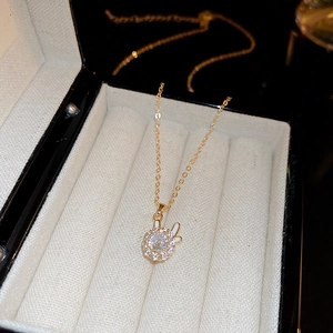 Macro view of gold-plated rabbit necklace with zircon stones in a black jewelry box