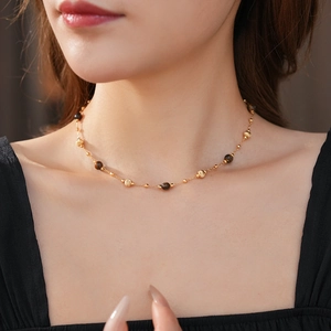Primo piano della collana di perline occhio di tigre placcata oro sul collo di una modella