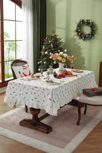 Detailed holly berry embroidery and ruffled edge on a festive white cotton tablecloth