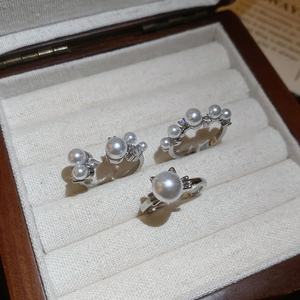 Detailed view of three silver rings with white pearls and zircons in a jewelry box